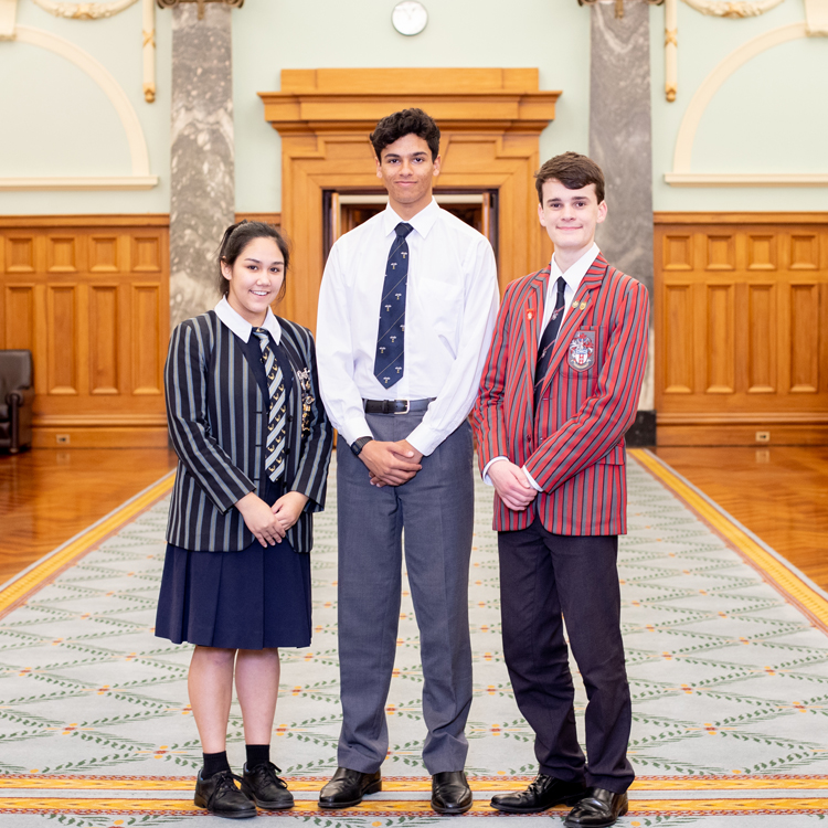 Three youth debaters standing in Parliament's Grand Hall