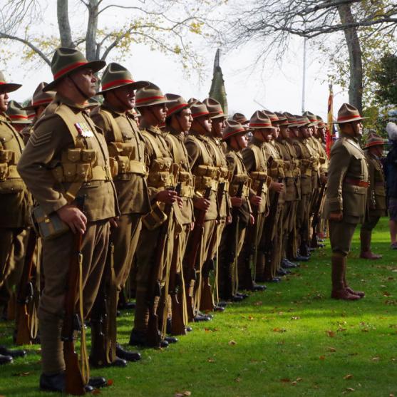 Line of men in replica uniforms of the Maori Pioneer Battalion